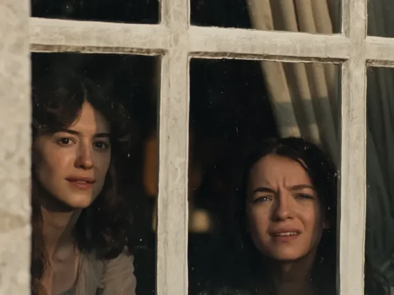 Daisy Edgar-Jones and Esmé Creed-Miles look through a window as Elinor and Marianne Dashwood