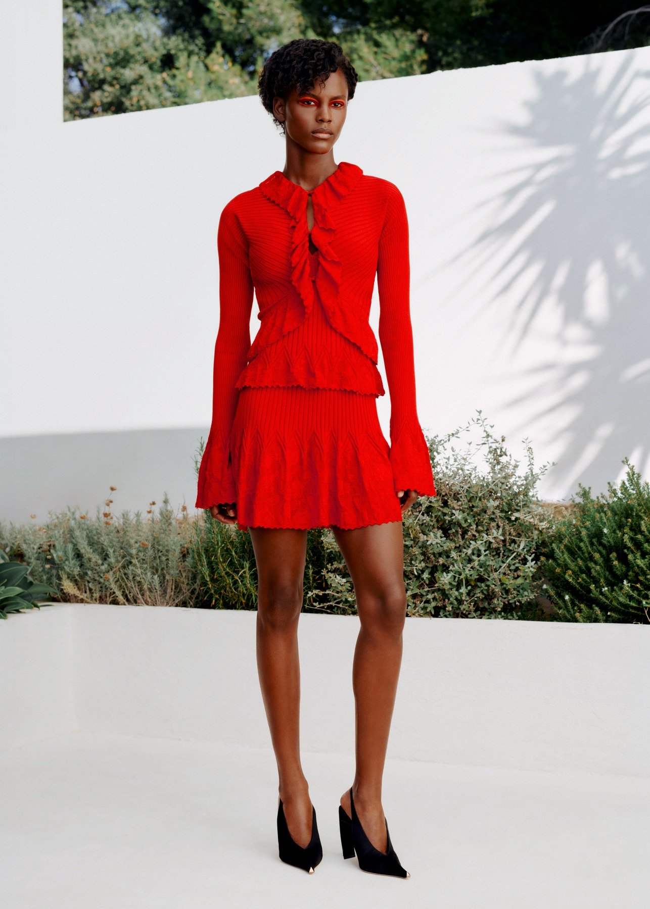 Red ArdAzAei ruffled cardigan and short textured skirt