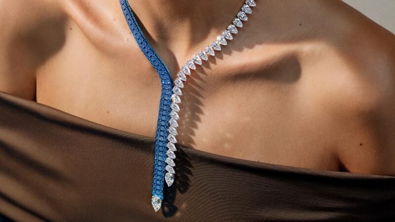 The Dream of Joux necklace combines blue gem-set links and pear-shaped diamonds against a dark top