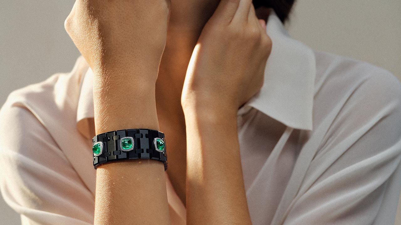 The Risoud Eclipse cuff features black links with green emeralds encircled by diamonds