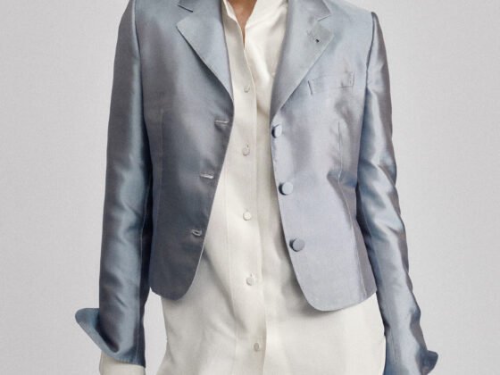 Model wearing a pale blue tailored jacket and matching trousers with an untucked white shirt.