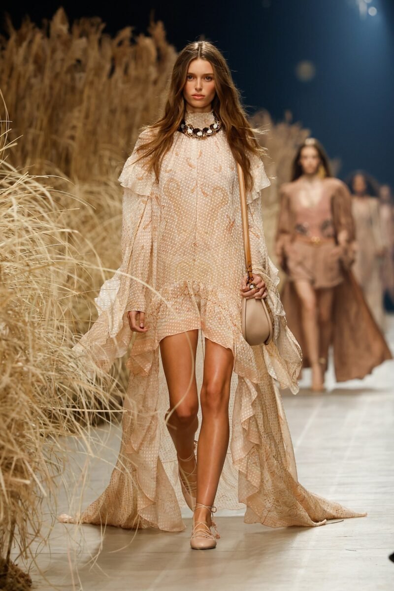 Etro spring–summer 2027 runway look with a sheer pale dress and flowing long outer layer