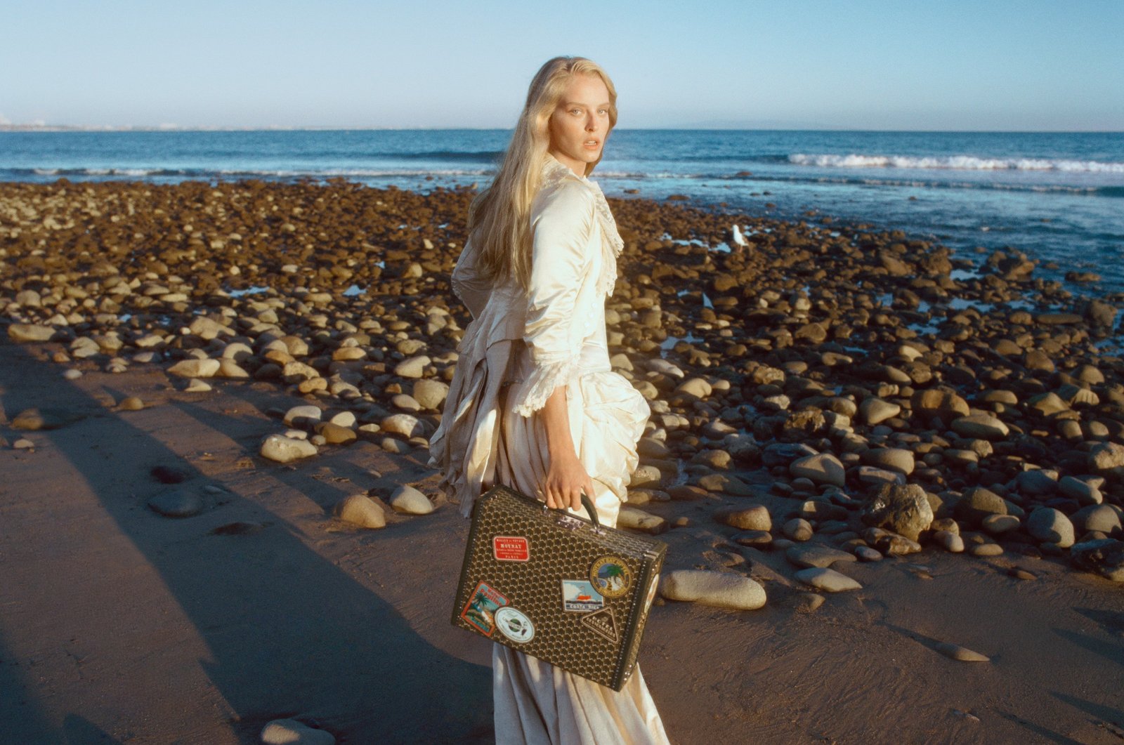 Abby Champion on the Malibu shoreline carrying a Hotel Moynat tote with leather travel patches