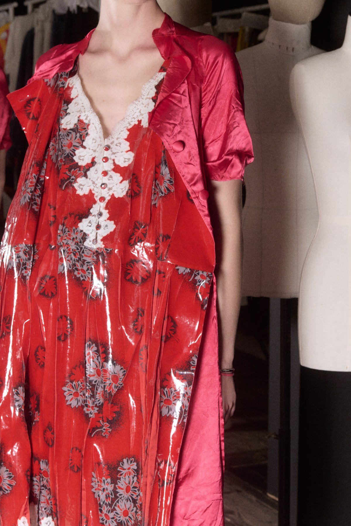 A close fitting photograph shows a red floral layer bordered by pale lace and surrounded by glossy red lining fabric