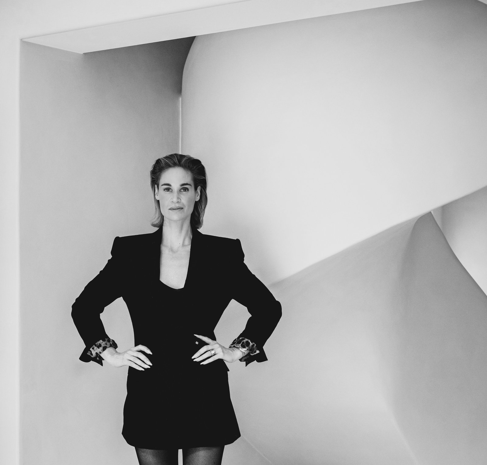 Black-and-white portrait of Ozanne Princen in a black jacket against a curved architectural wall