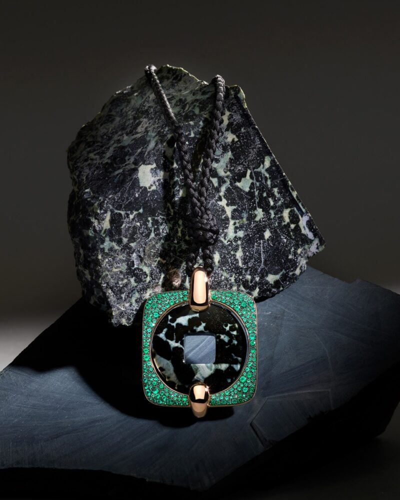 Green-bordered Pomellato Moneta Orientale pendant displayed against a dark mineral specimen