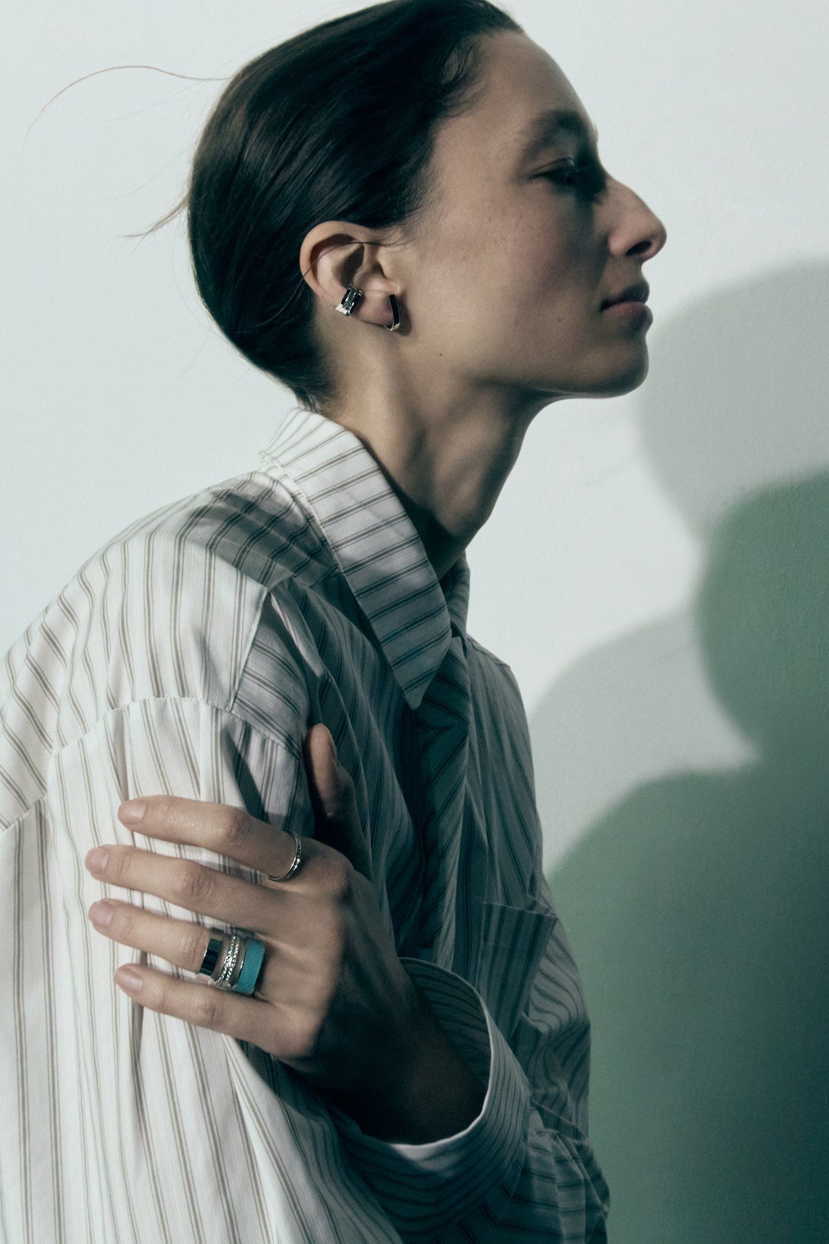 Model in profile wearing Repossi Berbère earrings and rings