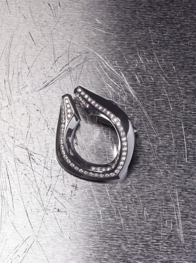 Repossi Limited Edition No.9 earring on a textured metallic surface
