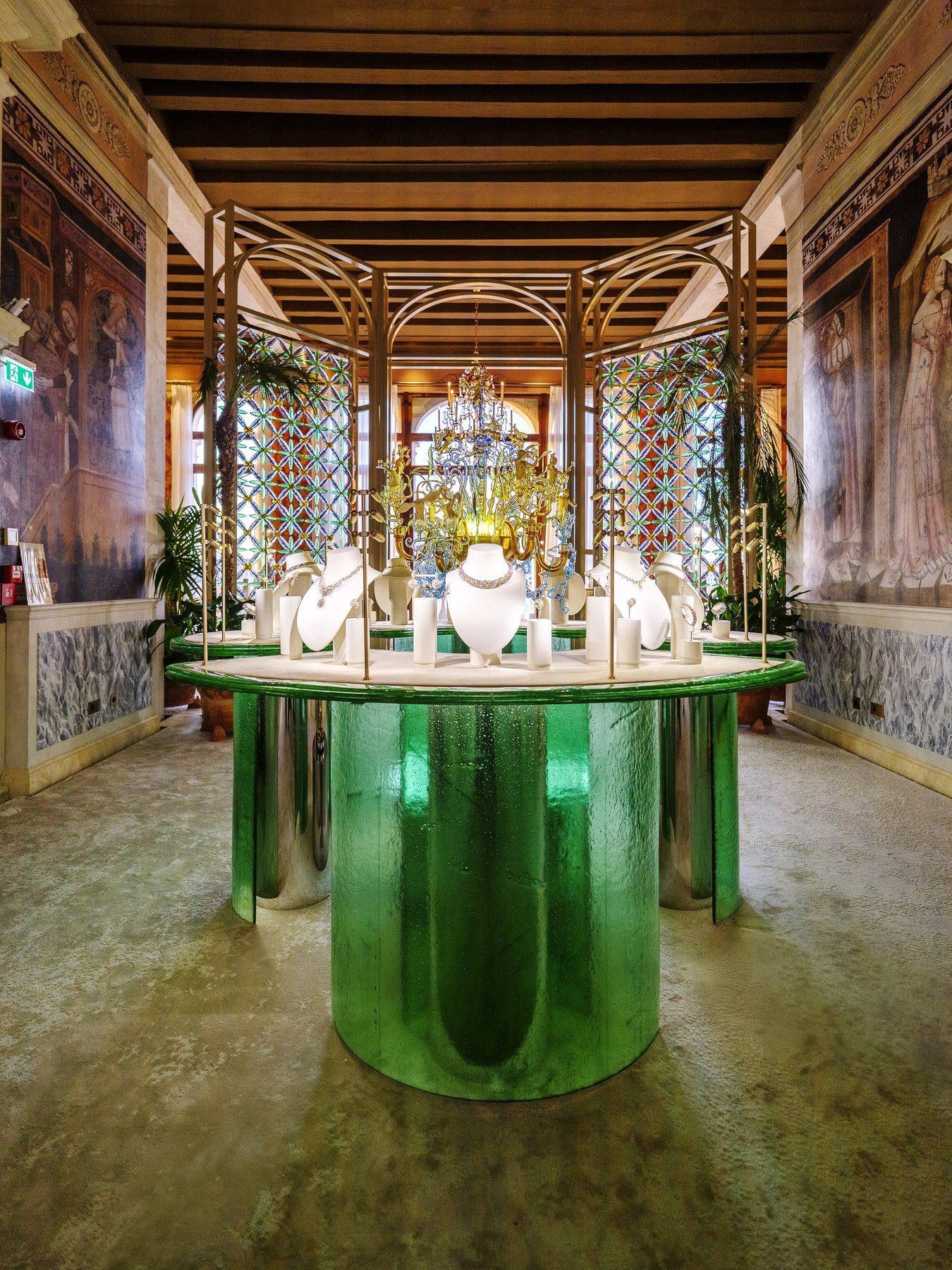 Green display cases in an ornate Venetian room at Tiffany’s Hidden Garden exhibition