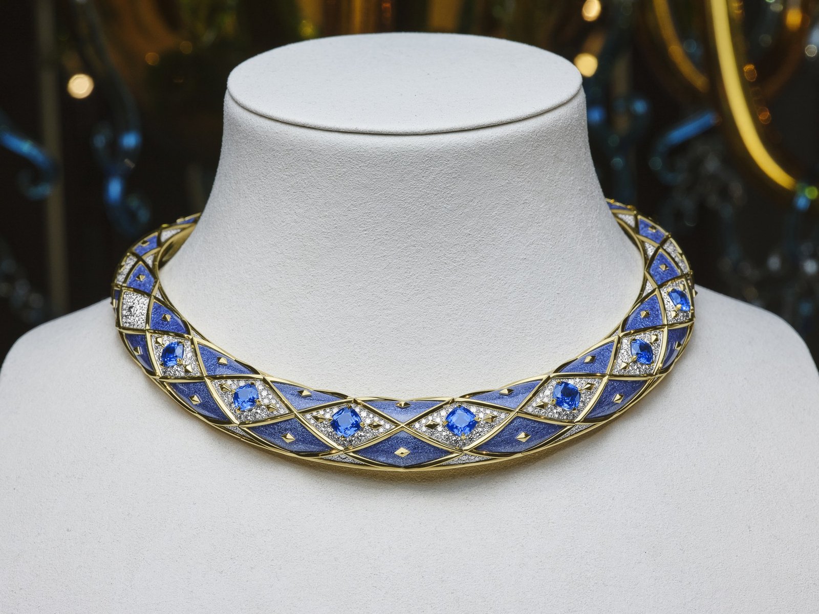 Tiffany collar necklace with blue geometric motifs on a white display bust