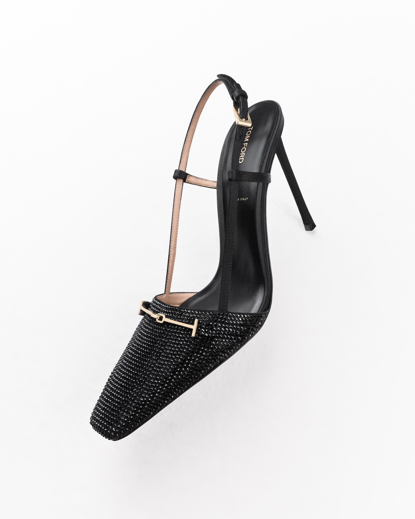 A black textured Tom Ford slingback pump with a narrow squared toe, slender heel and gold-tone T detail