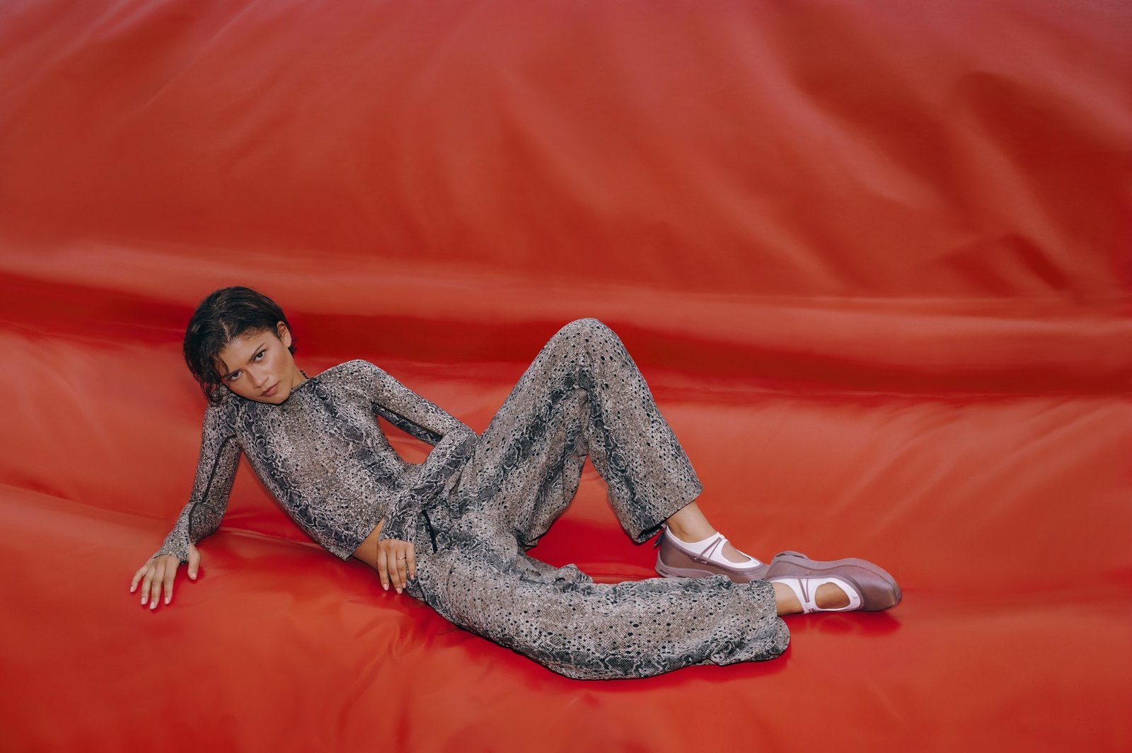 Zendaya in python-print sportswear against a red backdrop